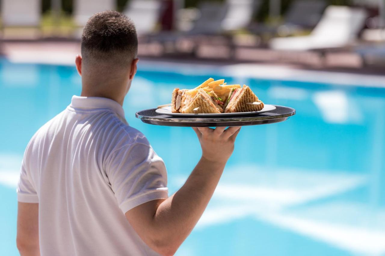 Hotel Du Lac Congress Center&Spa Ioannina Buitenkant foto A waiter serving food